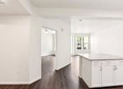 Thumbnail 38 of 42 - A kitchen with white cabinets and a wooden floor.