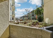Thumbnail 2 of 42 - A view of a courtyard with a bench and plants.