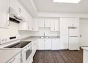 Thumbnail 37 of 42 - A kitchen with white appliances and cabinets.