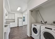Thumbnail 36 of 42 - A laundry room with a washer and dryer.