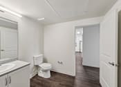 Thumbnail 35 of 42 - A white bathroom with a toilet, sink, and mirror.
