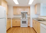 Thumbnail 10 of 17 - A kitchen with wooden cabinets and a white refrigerator.