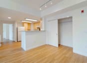 Thumbnail 13 of 17 - A spacious, empty room with wooden floors and white walls.