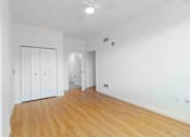 Thumbnail 15 of 17 - A room with white walls and wooden flooring, featuring a white wardrobe with a black frame.