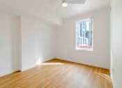 Thumbnail 17 of 17 - A room with a window and wooden flooring.