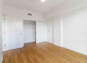 Thumbnail 3 of 17 - A room with wooden floors and white walls.