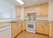 Thumbnail 4 of 17 - A kitchen with wooden cabinets and white appliances.
