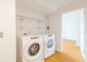Thumbnail 5 of 17 - Two white front loading washing machines in a laundry room.