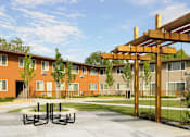Thumbnail 2 of 11 - A wooden pergola is in the middle of a concrete patio.