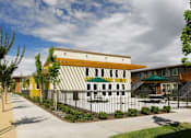 Thumbnail 9 of 11 - A modern building with a yellow and white striped facade.