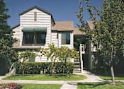 Thumbnail 3 of 4 - A house with a green awning and a tree in front.
