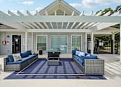 Thumbnail 3 of 107 - A patio with a white pergola and blue cushions.