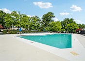 Thumbnail 9 of 107 - A large swimming pool surrounded by trees and a fence.