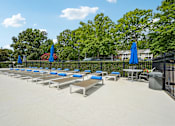 Thumbnail 10 of 107 - A poolside area with sun loungers and umbrellas.