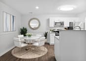 Thumbnail 13 of 49 - a dining area with a table and chairs and a kitchen in the background