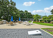 Thumbnail 100 of 107 - A concrete patio with chairs and umbrellas surrounded by greenery.