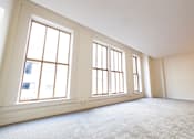Thumbnail 8 of 32 - an empty living room with three large windows at 26 West, Managed by Buckingham Urban Living, Indianapolis