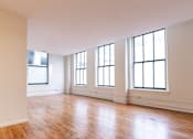 Thumbnail 20 of 32 - an empty living room with white walls and wood floors at 26 West, Managed by Buckingham Urban Living, Indianapolis