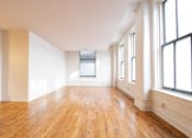 Thumbnail 24 of 32 - an empty room with hardwood floors and large windows at 26 West, Managed by Buckingham Urban Living, Indianapolis