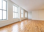 Thumbnail 25 of 32 - an empty living room with hardwood floors and large windows at 26 West, Managed by Buckingham Urban Living, Indianapolis