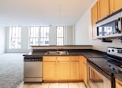 Thumbnail 4 of 32 - a kitchen with black countertops and white walls at 26 West, Managed by Buckingham Urban Living, Indianapolis