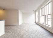 Thumbnail 9 of 32 - an empty room with large windows and a carpeted floor at 26 West, Managed by Buckingham Urban Living, Indianapolis