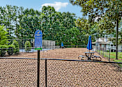 Thumbnail 89 of 107 - A baseball field with a blue sign and a picnic table.