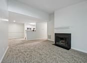 Thumbnail 71 of 107 - A living room with a fireplace and a carpeted floor.