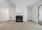 Thumbnail 66 of 107 - A living room with a fireplace and carpeted floor.