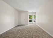 Thumbnail 84 of 107 - A room with a carpeted floor and a sliding glass door.