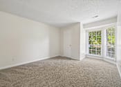 Thumbnail 79 of 107 - A room with a carpeted floor and a sliding glass door.