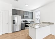Thumbnail 12 of 53 - A kitchen with a granite countertop and stainless steel appliances.
