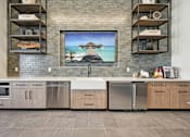 Thumbnail 19 of 26 - A kitchen with a large painting of a beach scene on the wall.