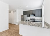 Thumbnail 15 of 53 - Open kitchen layout with dark cabinets and island at Nook Nine Apartments