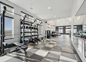 Thumbnail 25 of 26 - A spacious gym with a variety of equipment and a checkered floor.