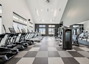 Thumbnail 23 of 26 - A gym with treadmills and elliptical machines.