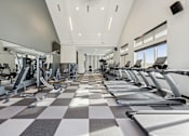 Thumbnail 24 of 26 - A gym with treadmills and elliptical machines.