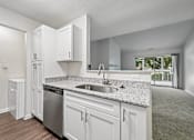 Thumbnail 73 of 107 - A kitchen with white cabinets and a granite countertop.