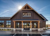 Thumbnail 5 of 26 - The Plato building has a dark brown facade and a black roof.