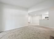 Thumbnail 65 of 107 - A large, empty room with carpeted flooring and white walls.