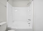 Thumbnail 62 of 107 - A white bathroom with a toilet and a bathtub.