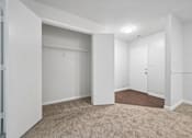 Thumbnail 58 of 107 - A white room with a carpeted floor and a door.