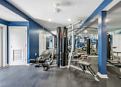 Thumbnail 87 of 107 - A gym with a row of treadmills and a row of exercise machines.
