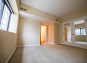 Thumbnail 14 of 18 - the living room of an empty house with a door to a hallway at The Ambassador at Library Square, Indianapolis, 46204