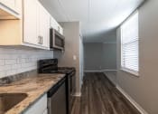 Thumbnail 27 of 35 - Brightly lit kitchen with granite countertops and hardwood floors at