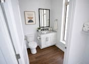 Thumbnail 5 of 22 - A white bathroom with a toilet, sink, and mirror.
