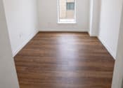 Thumbnail 10 of 22 - A room with wooden floors and a window.