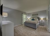 Thumbnail 48 of 49 - A bedroom with a bed, nightstand, and lamp.