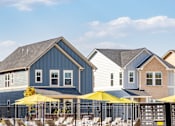 Thumbnail 37 of 37 - A row of houses with yellow umbrellas in front.