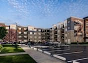 Thumbnail 8 of 8 - A large apartment complex with a parking lot in front.